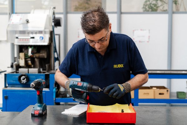 Monteur gebruikt een elektrische schroevendraaier in een productielijn voor lineaire beweging.